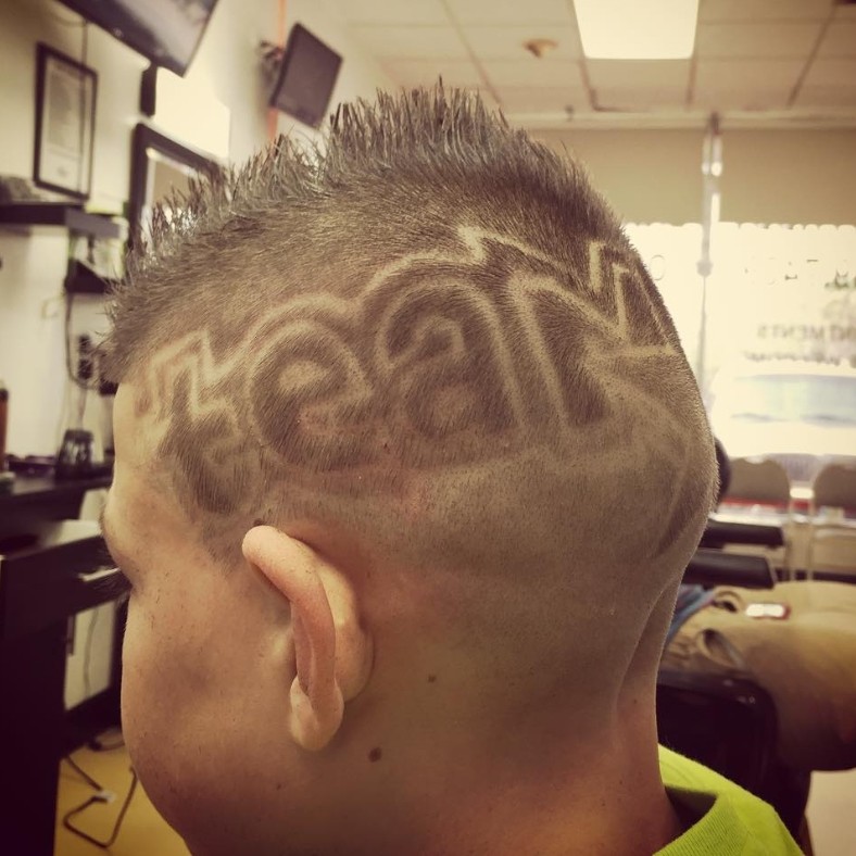 Custom hair design — 'team' lettering with sharp taper
